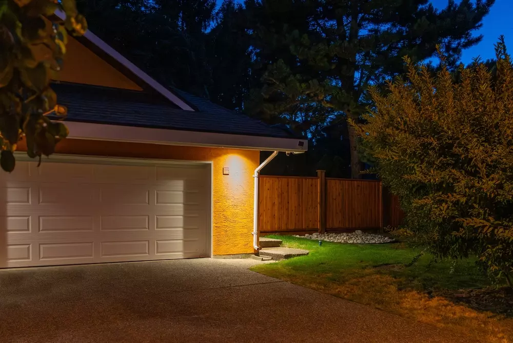 A garage door at night with a lantern.