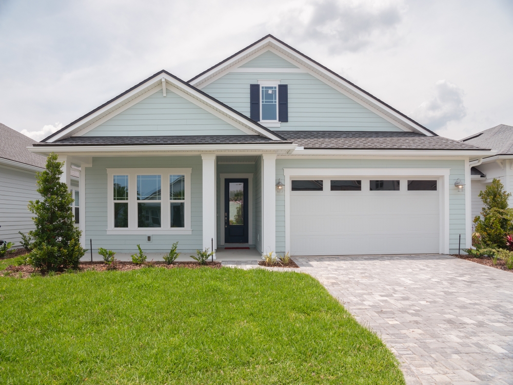 A small home with a window, front door, and garage.
